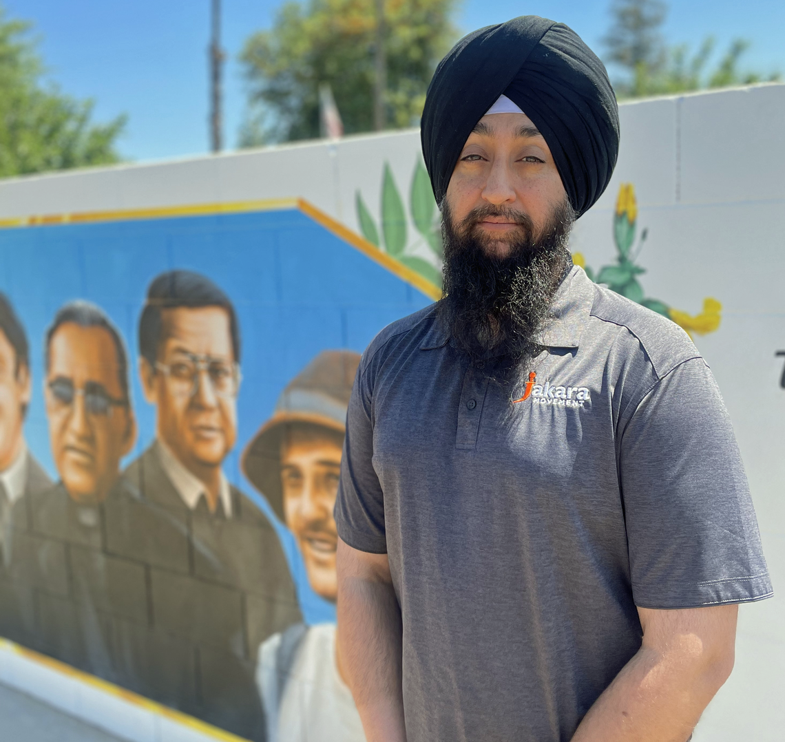 Naindeep (Deep) Singh, Central Unified School District trustee and executive director of The Jakara Movement, stands in front of a mural commissioned in his honor at Jaswant Singh Khalra Park on May 13, 2022.