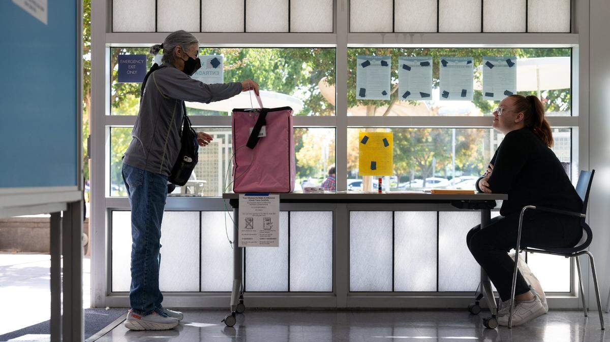 Rachel Fassnacht, watched by election officer Megan Lopes, votes at the North Natomas Library in Sacramento in 2023.