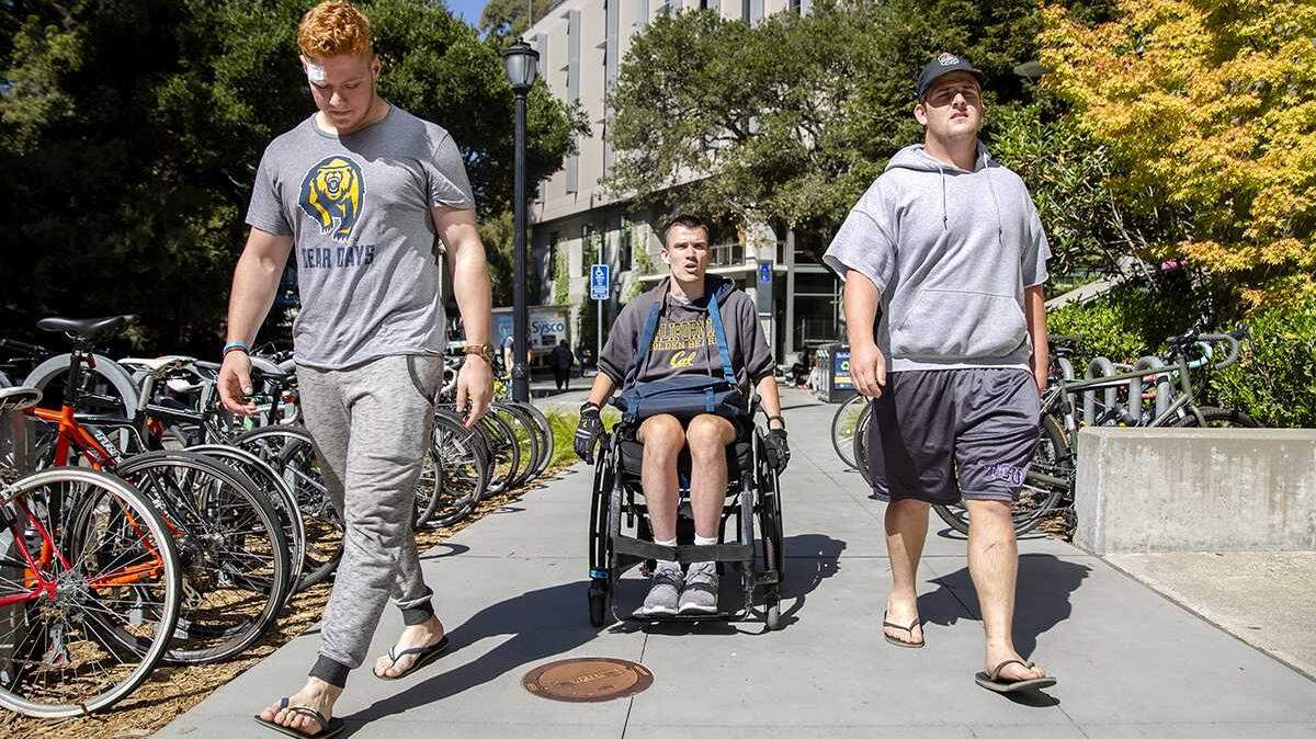 Jack Iscaro (left) and and Brian Joyce, two of Robert Paylors Rugby team mates, escort him to physical therapy at the High Performance center at UC Berkeley on Monday, Sept. 24, 2018. From a broken body and shattered dreams, Cal rugby player Robert Paylor has overcome odds to move again and to graduate. The Jesuit High School graduate aims to be a motivational speaker.