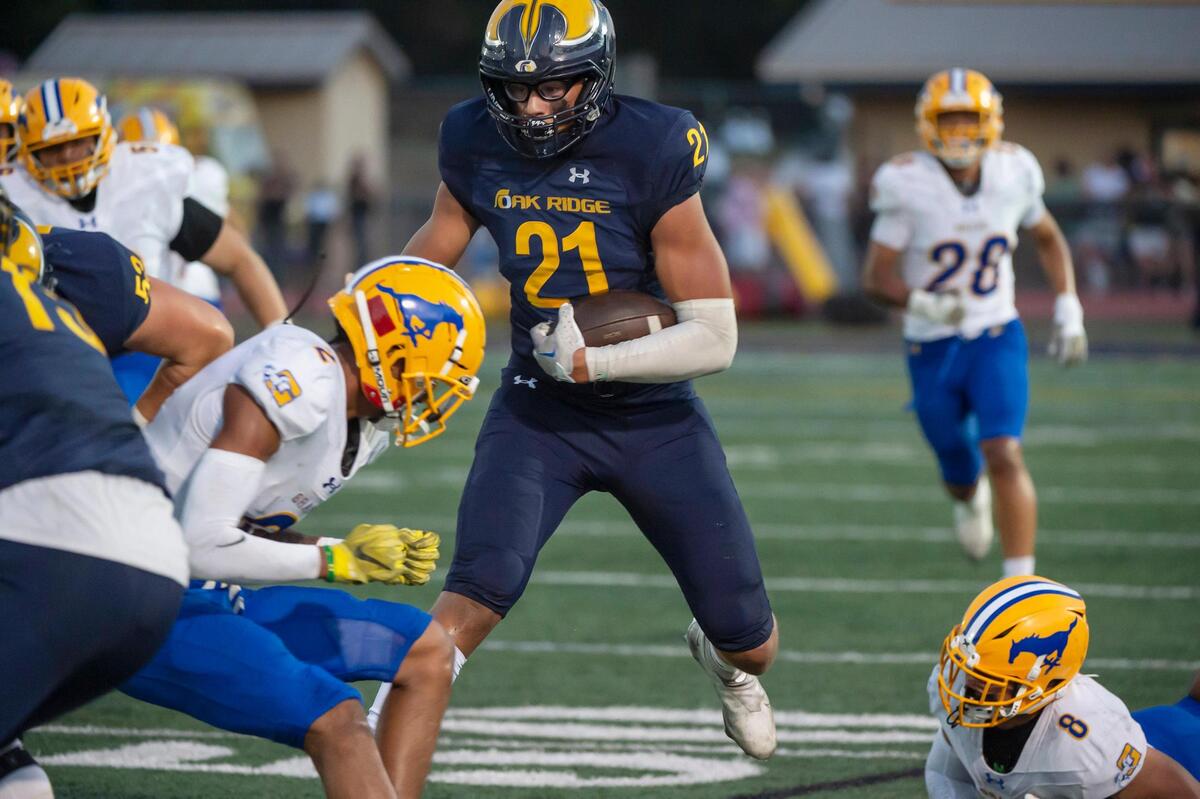 Oak Ridge Trojans’ Kaleb Edwards (21) runs the ball for a first down against Grant last year in El Dorado Hills.