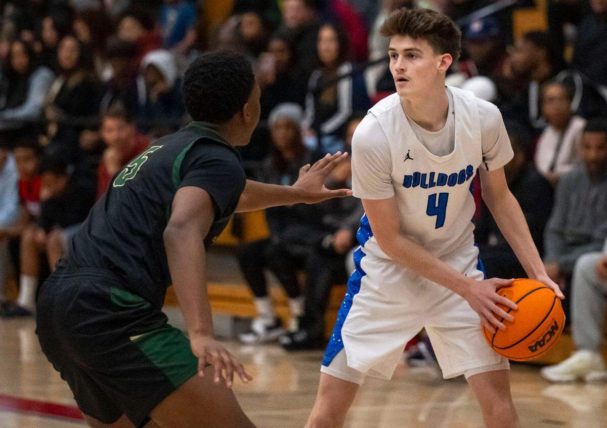 Folsom Bulldogs guard Chase Rawlins (4) looks to pass as the Monterey Trail Mustangs’ Devaughn Dorrough (5) defends in January.