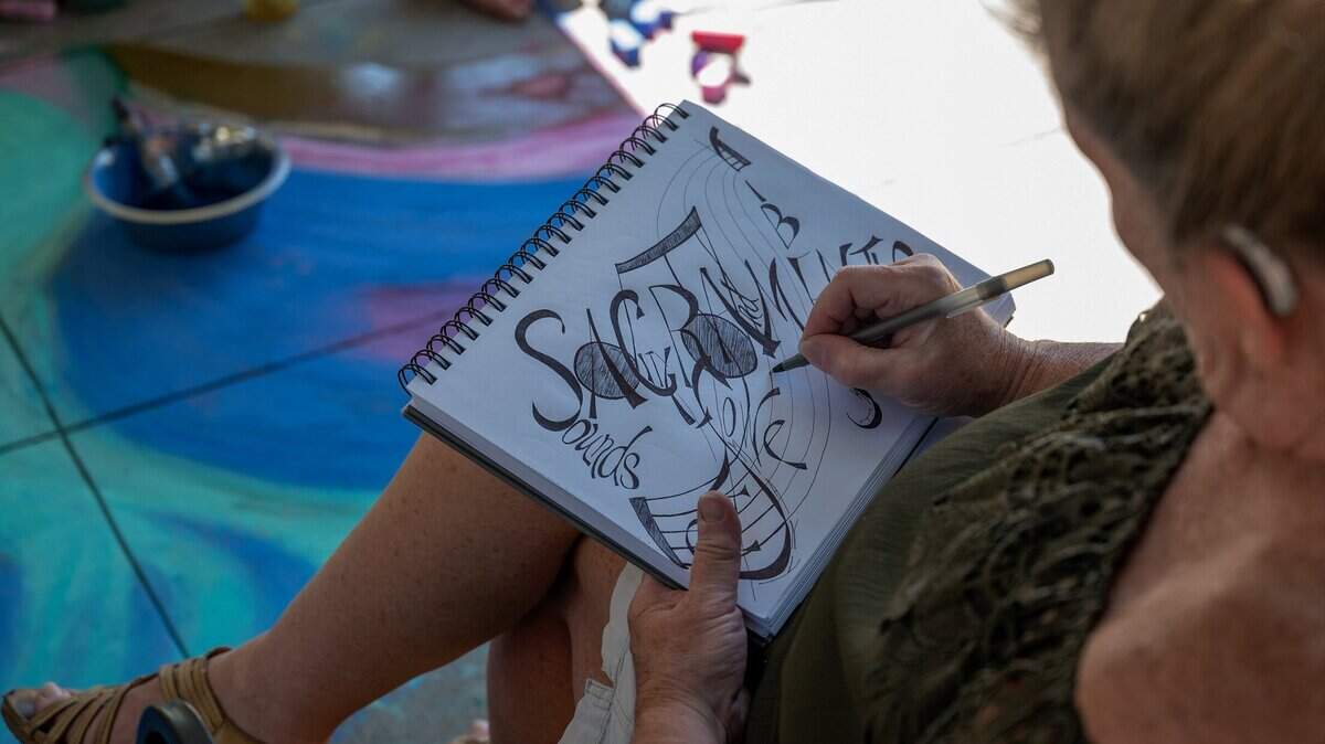 Lori Birks, of Sacramento, sketches while her son and granddaughter chalk a mural at the Chalk It Up Festival on Sunday, Sept. 4, 2022, at Fremont Park in Sacramento. The festival returns this year.