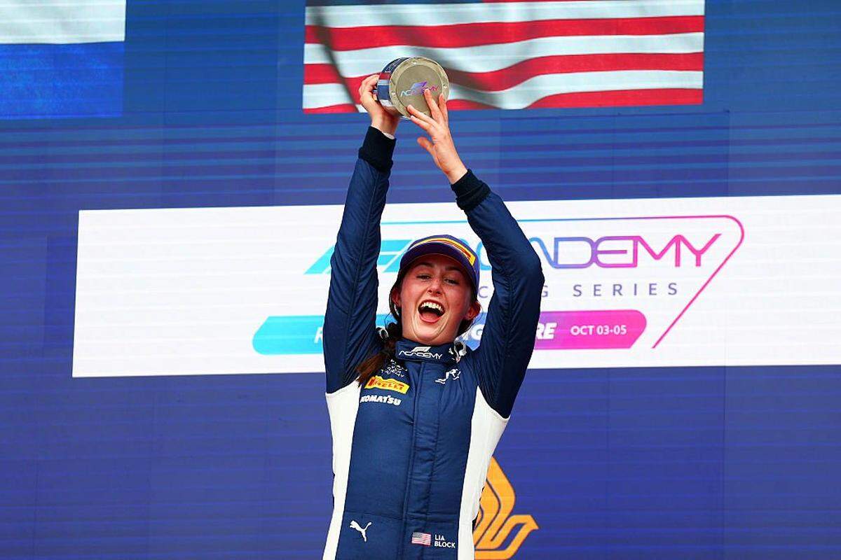 SINGAPORE, SINGAPORE - OCTOBER 04: Race winner Lia Block of United States and ART Grand Prix (57) celebrates on the podium with her trophy during F1 Academy Round 6, race 1 at Marina Bay Street Circuit on October 04, 2025 in Singapore, Singapore. (Photo by Bryn Lennon/Getty Images)