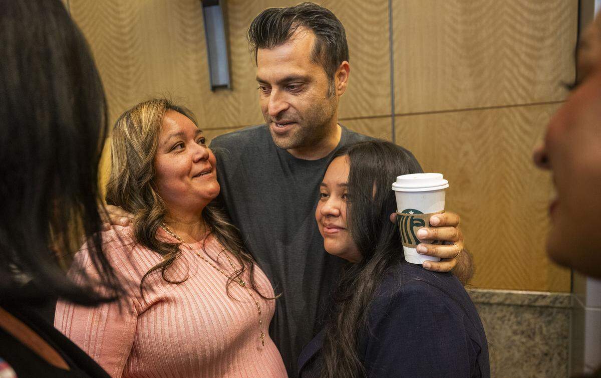 Maria de Jesus Estrada Juarez and her daughter Damaris Bello are hugged by Neeraj Paul at Sacramento City Hall on Tuesday, March 31, 2026. Paul, who goes by “Nick”, hired Estrada Juarez to be the regional manager for his business and began to advocate for her after she was deported to Mexico.  
