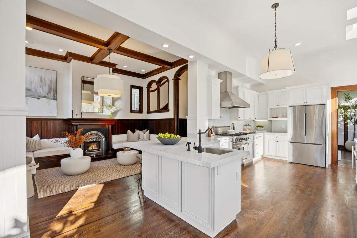 The bright chef’s kitchen, with Carrara marble counters, high-end appliances and a fireplace lounge, anchors the space.