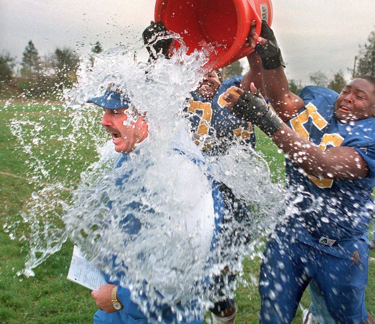 Grant head football coach Mike Alberghini gets a ritual ice water bath from tackles Jamar Brooks and Marin DuCre on Saturday, Nov. 11, 1997, at Grant High after a 44-24 victory over Del Campo sends them to the city championship against Elk Grove.