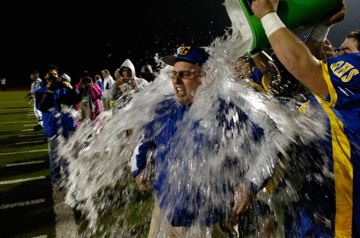 Grant coach Mike Alberghini is doused with water by his players after his team defeated Burbank 55-6 to capture the Sac-Joaquin Division II section championship at Folsom High School on Dec. 5, 2008.