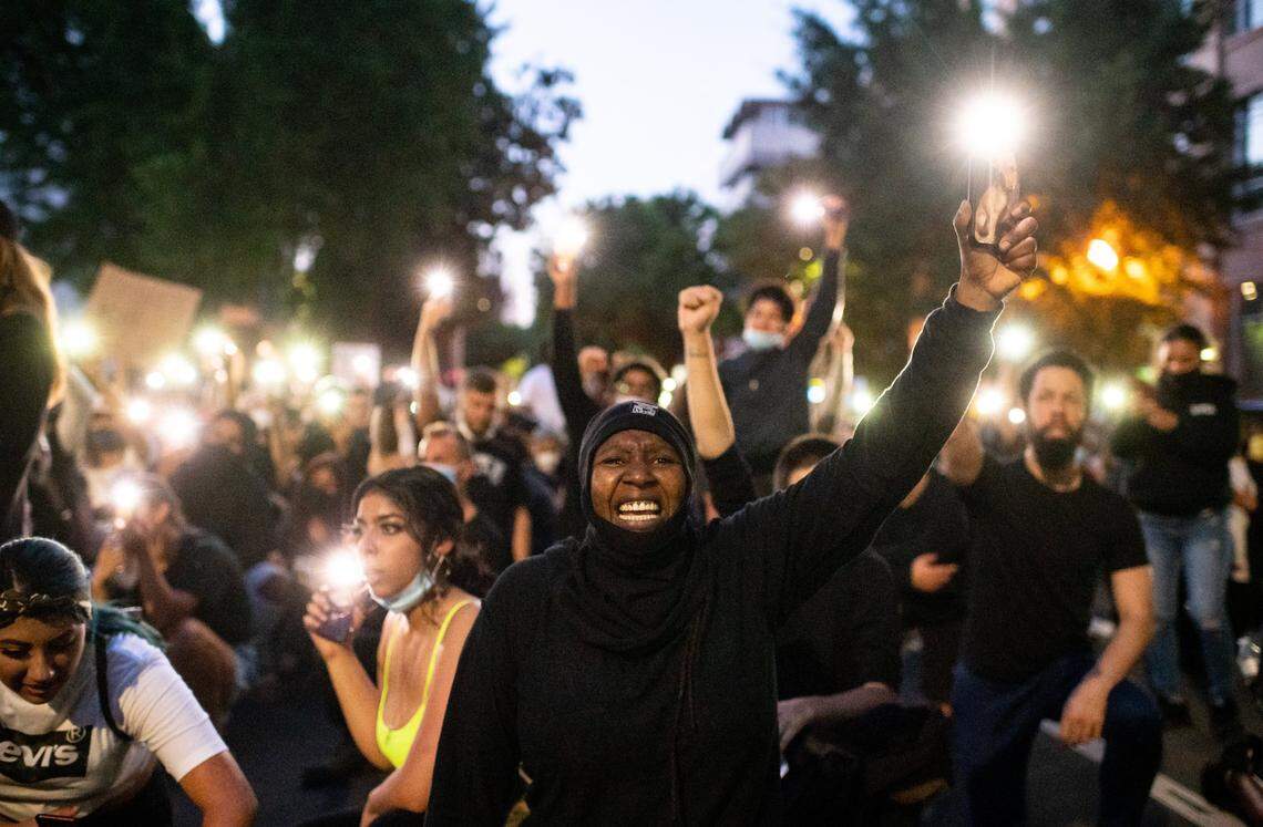 Musaqoi Young, of Sacramento, and others hold up their cell phones to honor Stephon Clark during a rally with his brother Stevante Clark in front of City Hall on Monday, June 1, 2020, in Sacramento after days of heated demonstrations to protest the death of George Floyd, who was killed by police in Minneapolis on Memorial Day. Young, who said sheís been with Black Lives Matter for four days, said people need to unite to fight against corrupt police in Sacramento ìbecause theyíre killing us like we donít matter, they treat us like weíre cattle,î she said, ìwe need to stop this.î The California National Guard was called in and citywide curfew implemented, while the looting by divergent groups and use of force from police that marked earlier days was largely absent.