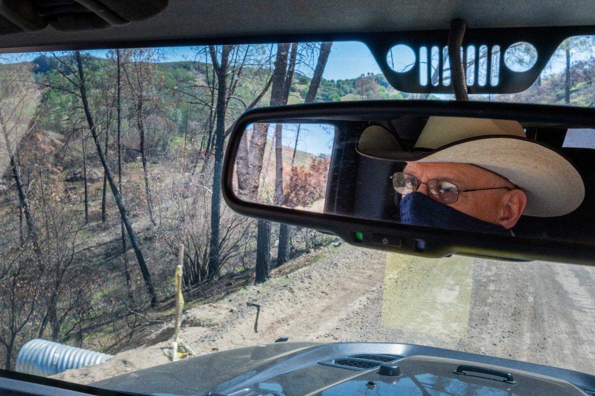 The charred remains of 2020’s LNU Lightning Complex Fire are visible as Randy Sternberg, who runs the ranching operations on the land planned for the $1 billion Guenoc Valley resort and housing development, drives through the property on April 12, 2021. The state Attorney General’s office has joined a lawsuit against the development, much of which is in a high hazard wildfire zone.