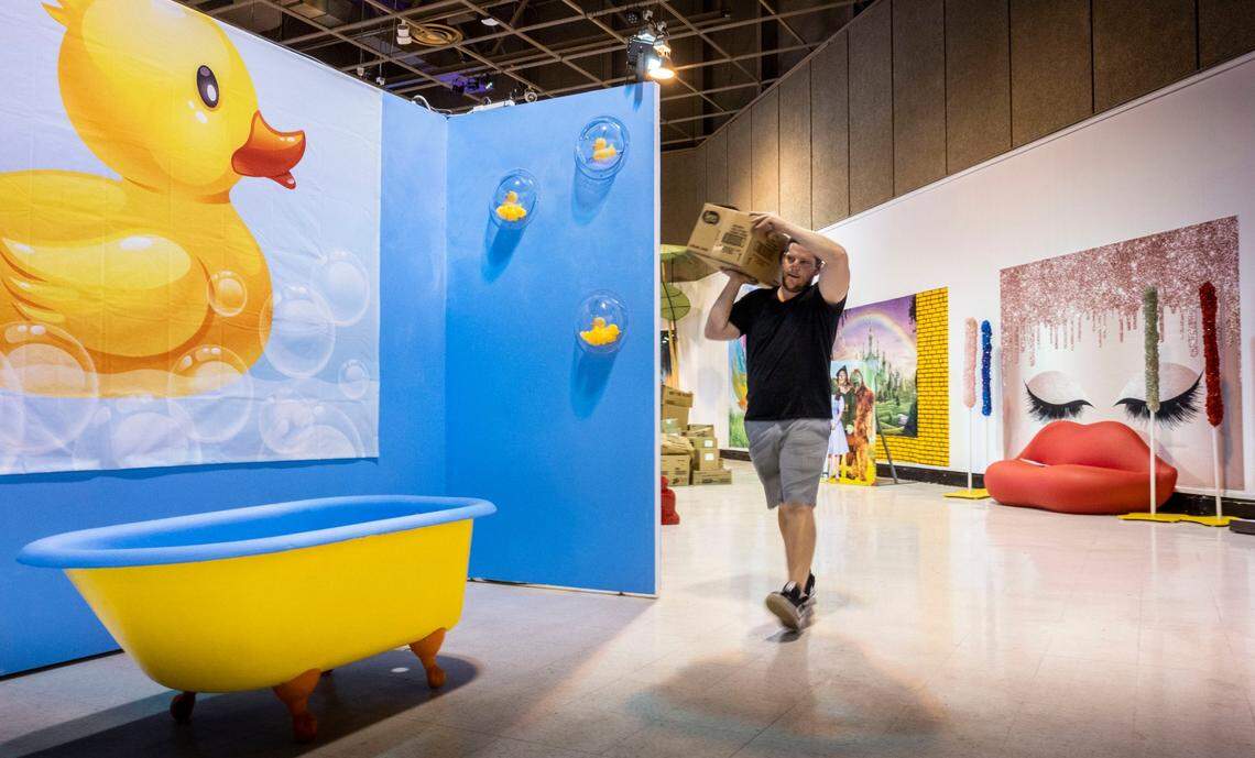 Adrian Kirschenann sets up a scene for the Selfie Experience in Expo Center Building 2 as the California State Fair takes shape on Monday.