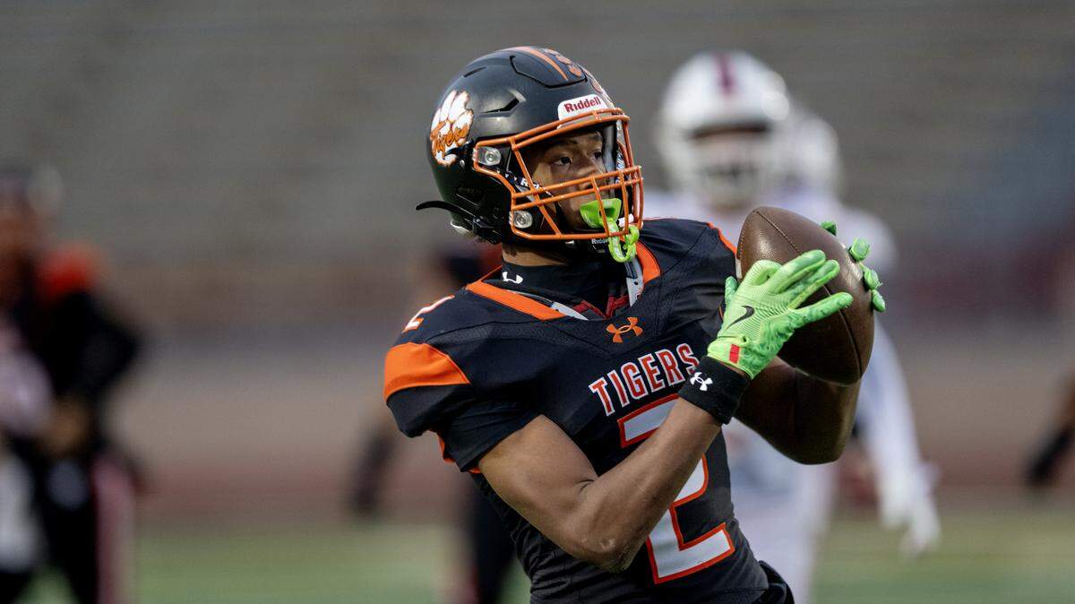 The Roseville Tigers' JJ Yong catches a pass and runs in for a touchdown in the first half of the CIF Sac-Joaquin Section football Division lV championship against the East Union Lancers on Nov. 29. Yong signed with Cal Poly this week.