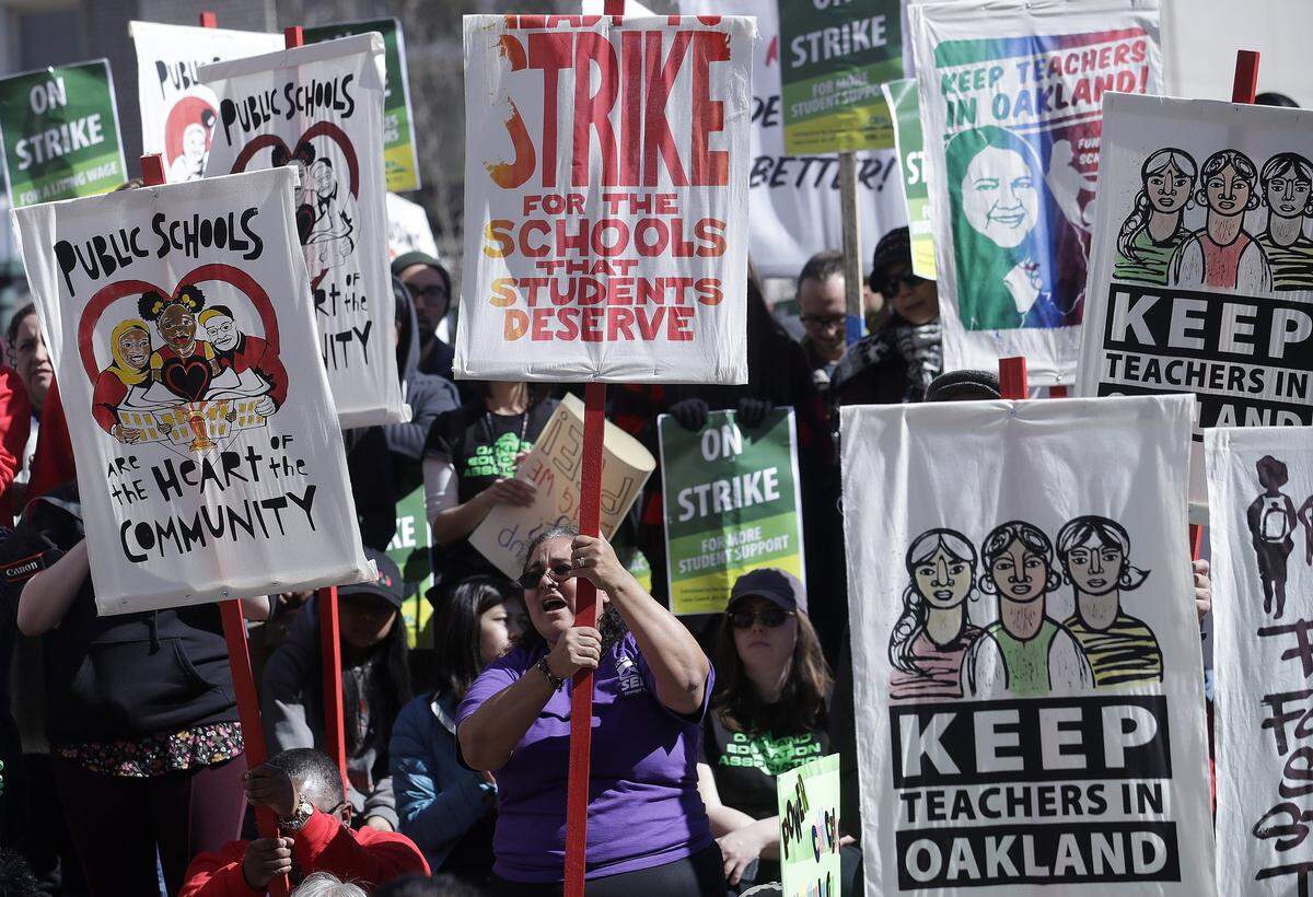 FILE - In this Thursday, Feb. 21, 2019 file photo, teachers, students and supporters rally at Frank Ogawa Plaza in front of City Hall in Oakland, Calif. Teachers in Oakland are preparing to strike for a third day after negotiations with the school district broke down over the weekend. (AP Photo/Jeff Chiu, File)