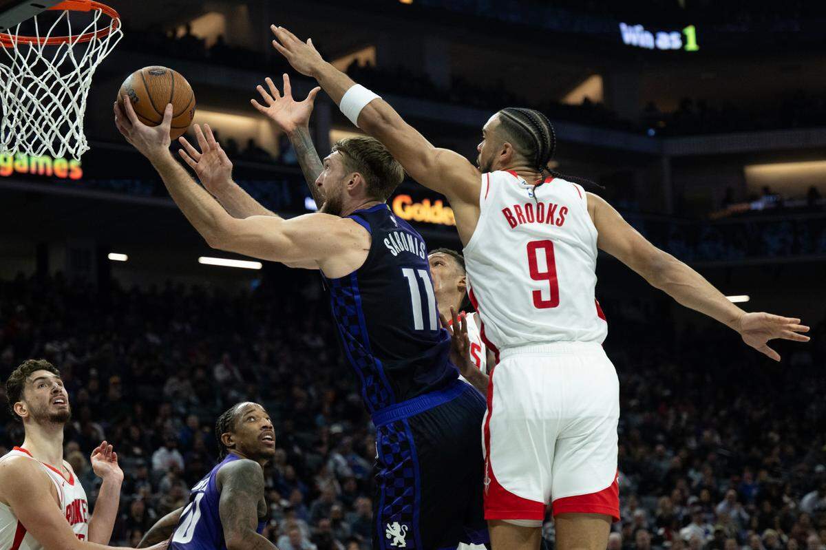 Sacramento Kings center Domantas Sabonis (11) drives to the basket against Houston Rockets forward Dillon Brooks (9) during an Emirates NBA Cup game at Golden 1 Center on Tuesday, Dec. 3, 2024.