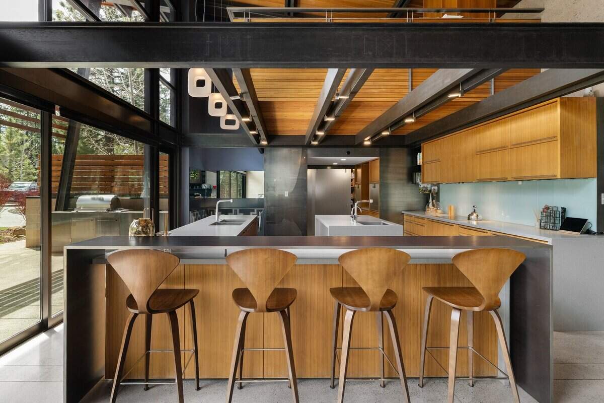 The kitchen is outfitted with Gaggenau appliances and custom cabinetry, with adjacent gathering areas and a lofted office positioned for views toward Northstar, a ski resort just six miles away.
