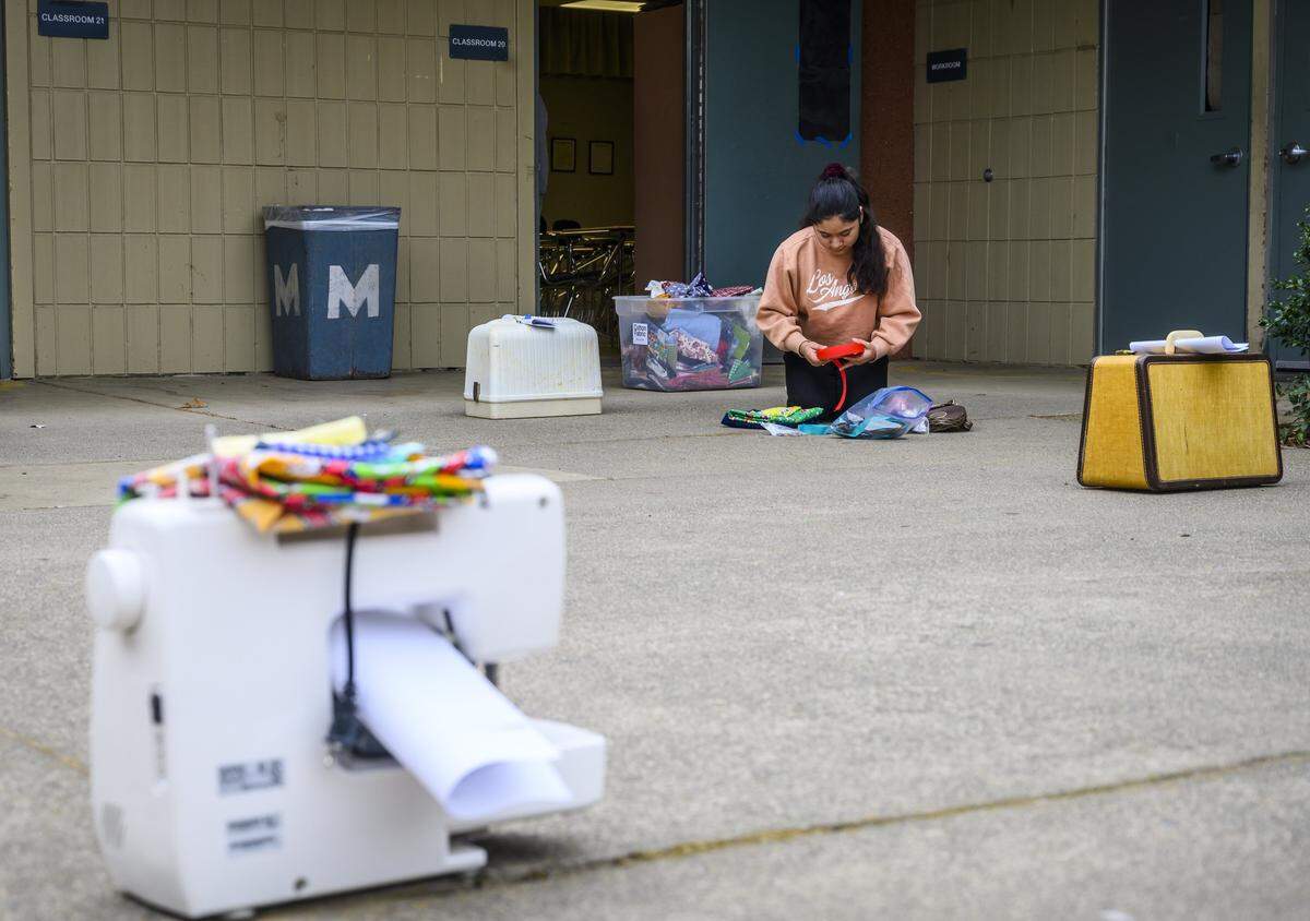 6th grader Pamela Lopez picks out sewing supplies at W. E. Mitchell Middle School in Rancho Cordova on Wednesday, April 1, 2020. Two teachers who started a sewing club after school, decided to distribute sewing machines to their students while the school is closed during the coronavirus pandemic. The machines were placed outside the classroom about 6-10 feet apart so that the students could maintain their social distance.