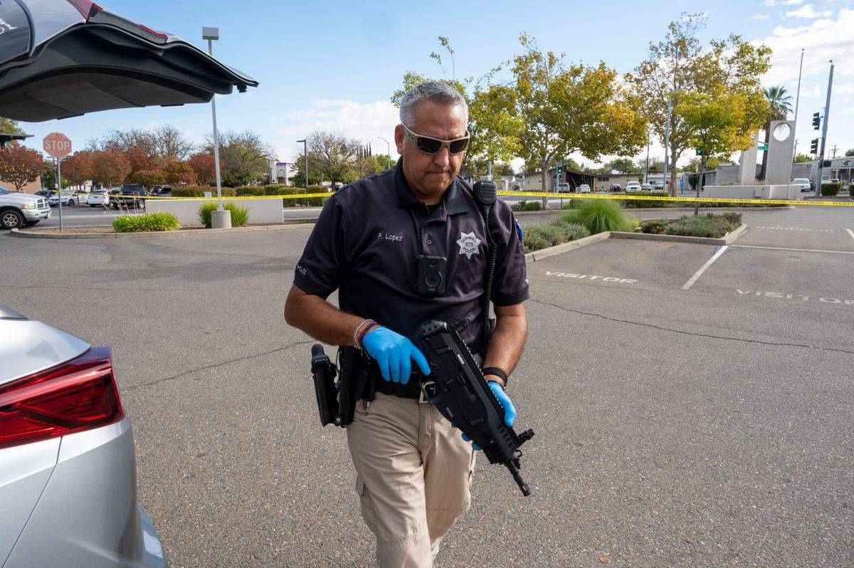 Sacramento Police officer Peter Lopez carries a firearm from a participant at at a gun buyback event at the Sacramento Police Department headquarters Saturday.