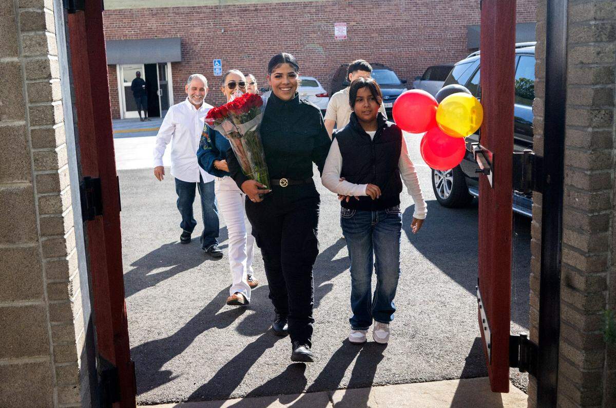 Britaney Gomez walks with her sister Genesis Vega as she participates in the Tuesday graduation ceremony for a first-ever program to train female inmates at St. John’s Lutheran Church in Sacramento.