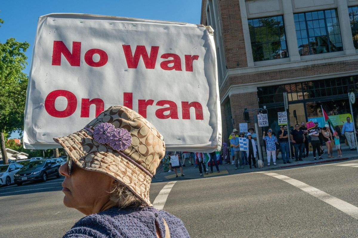 Marcy, 63, who is Iranian and declined to give her last name out of fear, demonstrates against war in Iran at 16th and J streets in Sacramento on Wednesday. She said she was worried about her family in Iran.