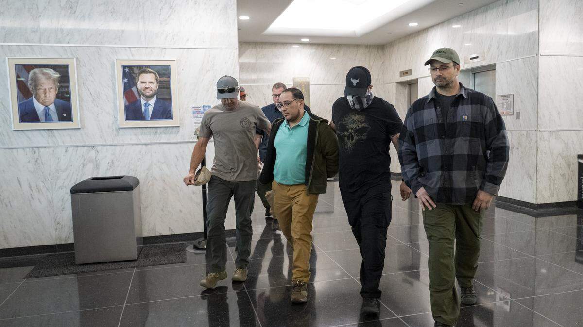 An individual is walked in handcuffs by federal authorities into a U.S. Immigrations and Customs Enforcement office in the John E. Moss federal building in downtown Sacramento on Wednesday, June 11, 2025.