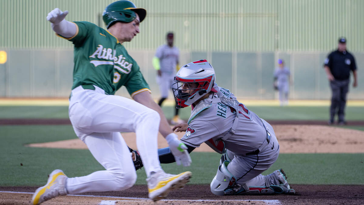 Athletics baserunner Tyler Soderstrom scores past a sweeping tag by Arizona Diamondbacks catcher Jose Herrera at Sutter Health Park on Friday in West Sacramento.