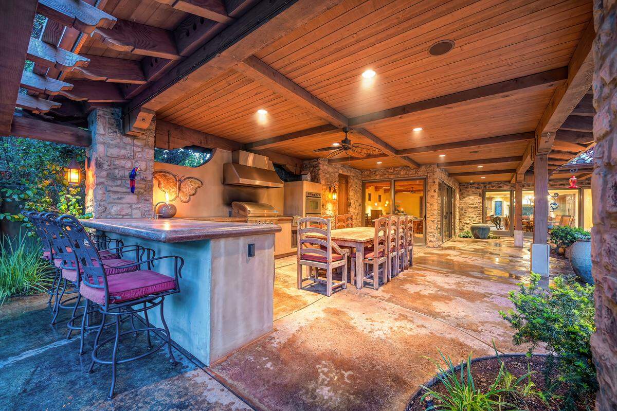 A sprawling pool, outdoor kitchen and garden beds anchor the backyard, designed for everything from quiet afternoons to large gatherings in a setting that feels like a private resort.