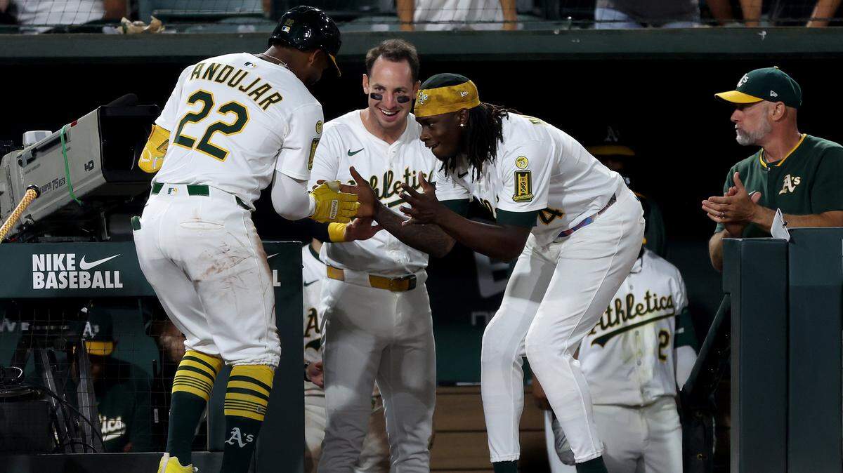Athletics center fielder Lawrence Butler, left, celebrates with third baseman Miguel Andujar after Andujar hit a solo home run against the Seattle Mariners during the seventh inning Wednesday at Sutter Health Park in West Sacramento.
