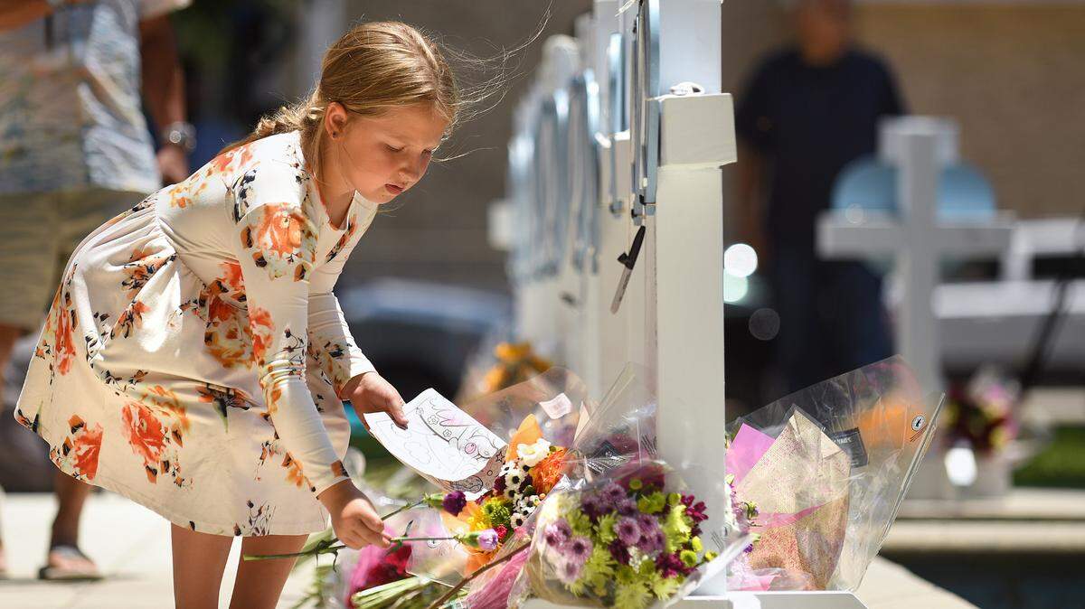 Kymber Guzman, 8, places flowers at a memorial for the victims of a mass shooting in Uvalde, Texas, on Thursday, May 26, 2022. Nineteen students and two teachers died when a gunman opened fire in a classroom Tuesday. (Wally Skalij/Los Angeles Times/TNS)