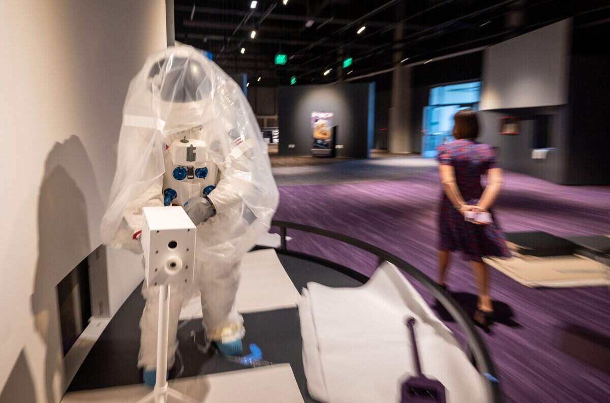A spacesuit in a portion of the under-construction Destination Space exhibit at the SMUD Museum of Science and Curiosity – also known as MOSAC – stands nearly ready for public viewing Sept. 9, as Executive Director Michele Wong walks past on the second floor of the Sacramento museum.