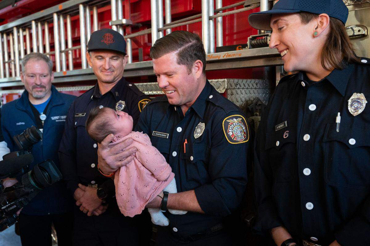 Firefighter Jeff Switkowski holds baby Dalyza on Wednesday as Sacramento firefighters from Station 6 are reunited after they saved the newborn in an extraordinary roadside delivery earlier this year.