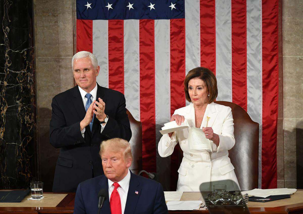 Vice President Mike Pence claps as Speaker of the House  Nancy Pelosi rips up a copy of President Donald Trump speech after he delivers the State of the Union address on Feb. 4, 2020.