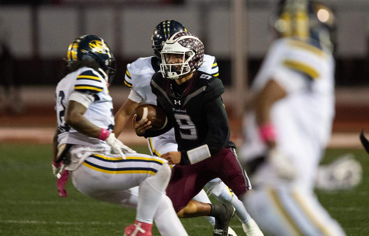Woodcreek Timberwolves quarterback Josiah Melendez (9) successfully darts between two Inderkum defenders on a keeper on Friday in Roseville. 