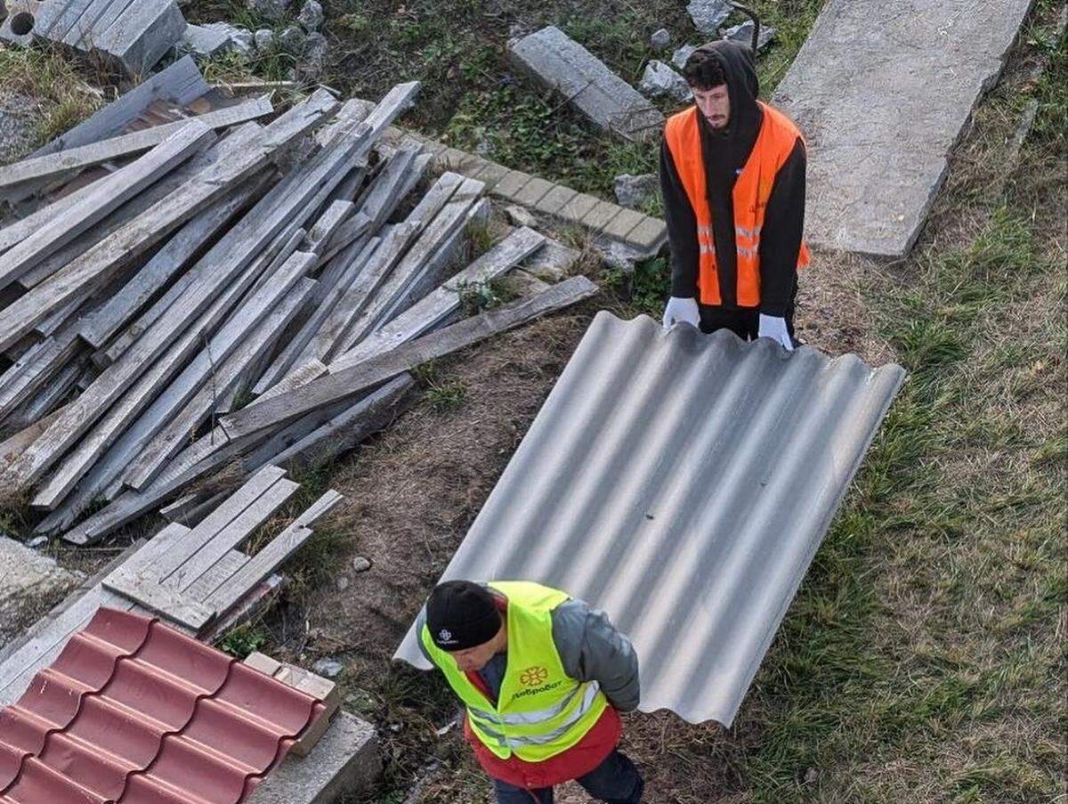 The author helping carry a roof tile during his time with Dobrobat.