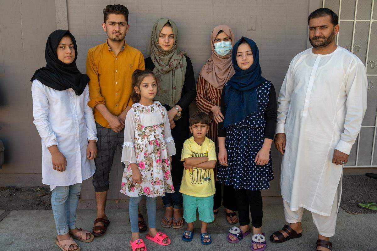 Abdul stands with his family in the new apartment complex. Back row: Istoray, 15, Rashed, 20, Suraya, 19, wife Adela, 41. Front row: Hasiba, 8, Abdullah, 4, and Zulaikha, 13.