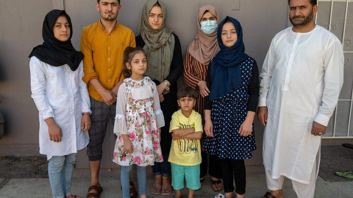 Afghan refugee Abdul, 46, right, a Special Immigrant Visa holder, stands alongside his family from left back row; Istoray, 15, Rashed, 20, Suraya, 19, mom Adela, 41, and front row Hasiba, 8, Abdullah, 4, and Zulaikha,13, in his new apartment complex in Sacramento on Monday Sept. 20, 2021. The family left Afghanistan Sunday Aug. 16th arriving in Sacramento on that following Monday, fleeing the Taliban that had just taken control of Kabul.