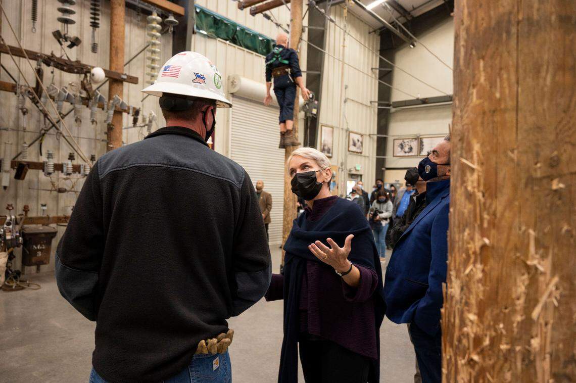 U.S. Energy Secretary Jennifer Granholm, center, talks with Cayleb Bowman, a line foreman with SMUD, as she tours the Sacramento Power Academy on Friday. Granholm made a pitch for the president’s stalled Build Back Better climate and social-spending bill.