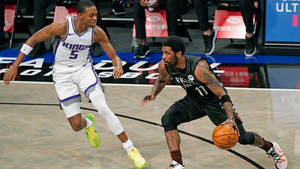 Brooklyn Nets guard Kyrie Irving (11) drives to the basket with Sacramento Kings guard De’Aaron Fox (5) defending during the first quarter of an NBA basketball game, Tuesday, Feb. 23, 2021, in New York. (AP Photo/Kathy Willens)