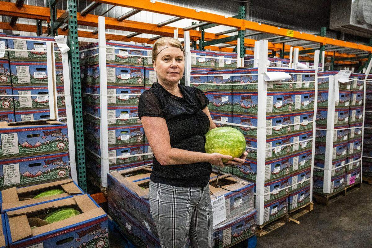 Diana Flores, Sacramento City Unified executive director of nutrition at The Central Kitchen, holds a watermelon inside a walk-in food cooler in August. The district has a new 50,000 square foot production facility where it prepares fresh meals to go out to 43 schools.