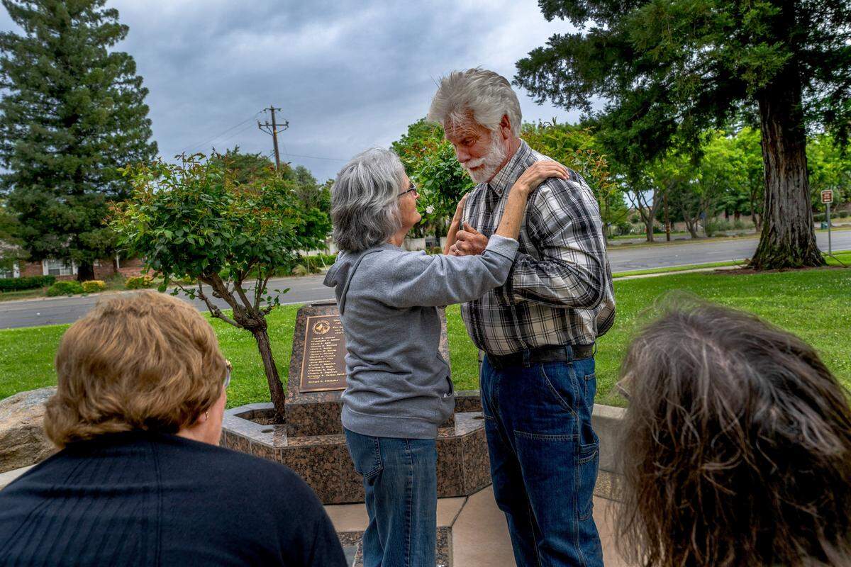 Richard Ethington, a survivor of the 1976 bus crash that killed 28 Yuba City High School choir students and a music teacher, is greeted by Lisa Covington Bubienko on Monday in Yuba City at a memorial built in 2011. Ethington was sitting behind the bus driver during the crash, and his testimony helped change transportation safety. Bubienko helps coordinate annual memorial events to “continue to heal.”