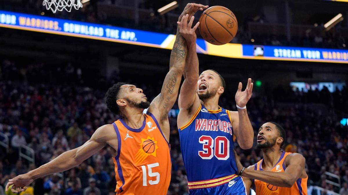 Phoenix Suns guard Cameron Payne (15) defends against a shot attempt by Golden State Warriors guard Stephen Curry (30) during the first half of an NBA basketball game in San Francisco, Friday, Dec. 3, 2021. (AP Photo/Jeff Chiu)