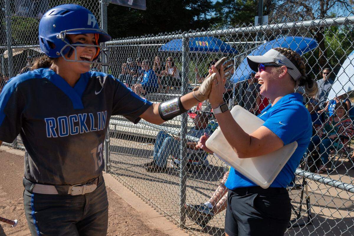 Rocklin High School Bella Garcia is congratulated by coach Mallory Asaro after scoring a run in the fourth inning against McClatchy High School during playoff game in Rocklin on Tuesday.