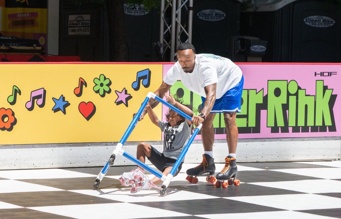 Tre Bird, 6, left, falls while skating with his dad, Christopher Bird, at the Downtown Roller Rink in downtown Sacramento’s Ali Youssefi Square on Friday, June 28, 2024. Sharon Bird, Trey’s mom, said going to the rink as a family is fun and a good form of exercise.