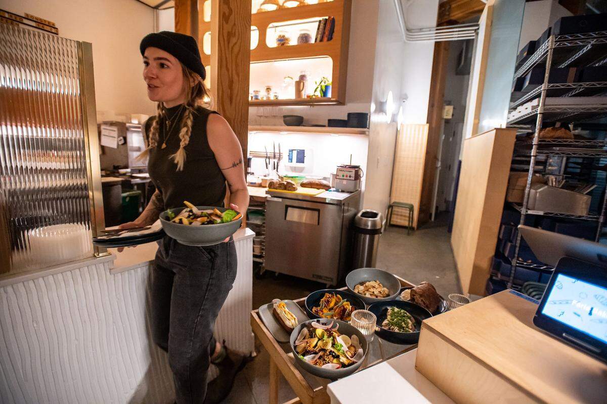 Faria Bakery’s supper club lead Gina Geissinger, leaves the small kitchen to serve a dish during service Nov. 9, 2022. Owner Christopher Beattie announced this month that the bakery would lower its menu prices and .
