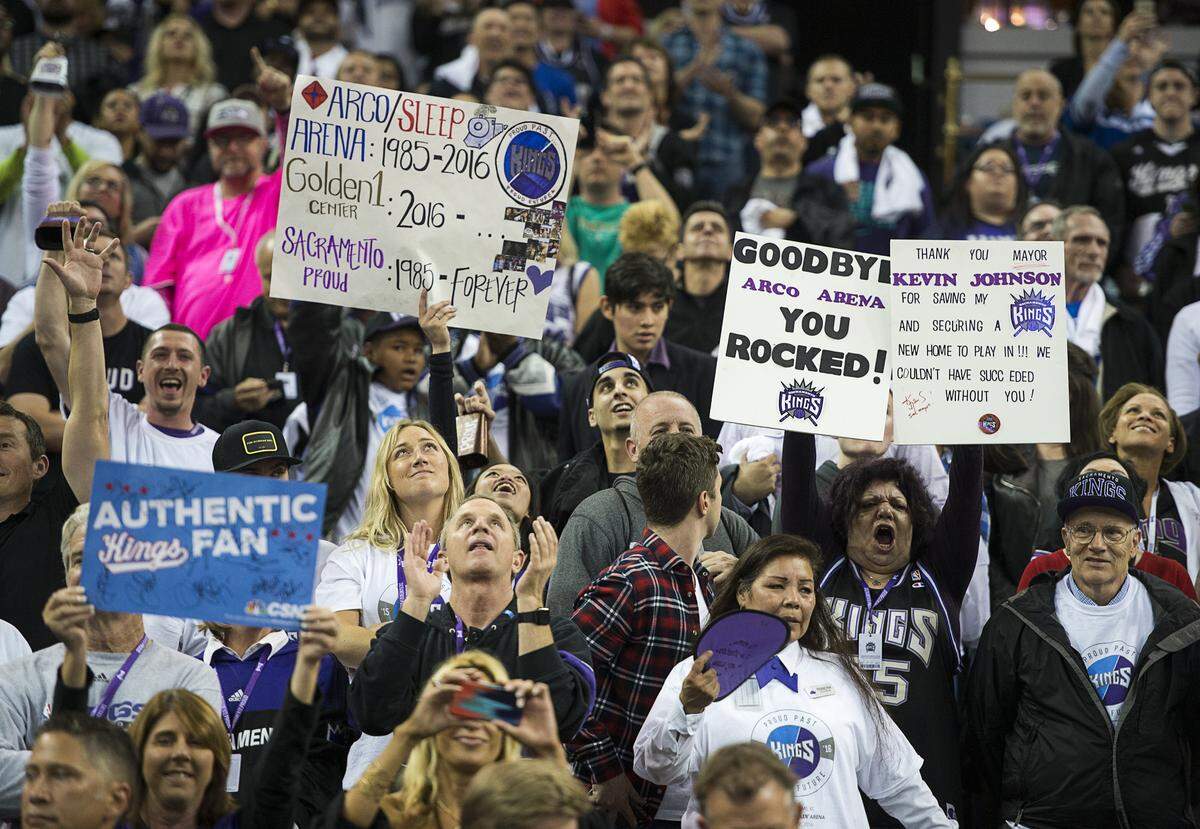 Sacramento Kings wave their signs as they watch the team cut down the net after the last game at Sleep Train Arena on April 9, 2016.
