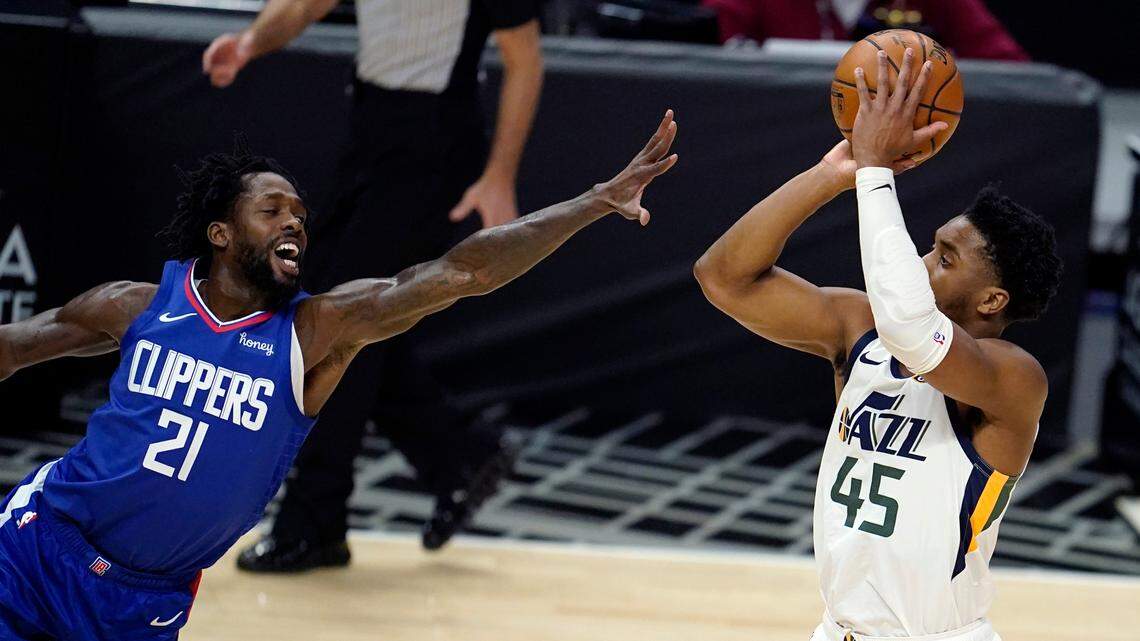 Utah Jazz guard Donovan Mitchell, right, shoots over Los Angeles Clippers guard Patrick Beverley during the first half of an NBA basketball game Wednesday, Feb. 17, 2021, in Los Angeles. (AP Photo/Marcio Jose Sanchez)