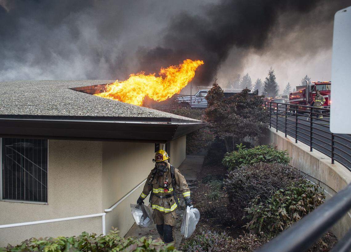 Josh Wilkins with Cal Fire removes belongings from the radiology building that was fully engulfed in flames at the Feather River hospital in Paradise as the Camp Fire raged on Thursday, Nov. 8, 2018.