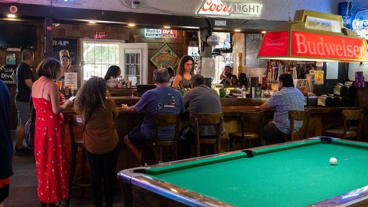 Mariah Lukenbill, daughter of former Sacramento Kings owner Greg Lukenbill, serves drinks to her customers at The Trap in Sacramento on Monday, July 7, 2025. 