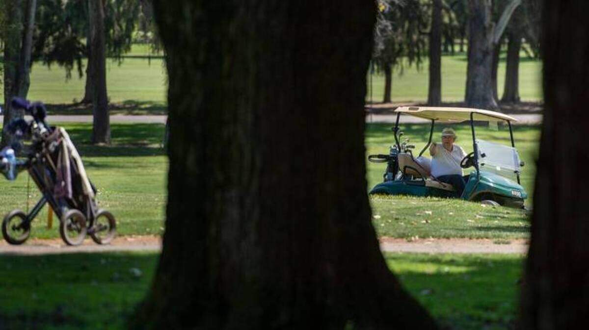 Don Sperling drives a golf cart and gestures at William Land Park Golf Course in Sacramento in June 2018.