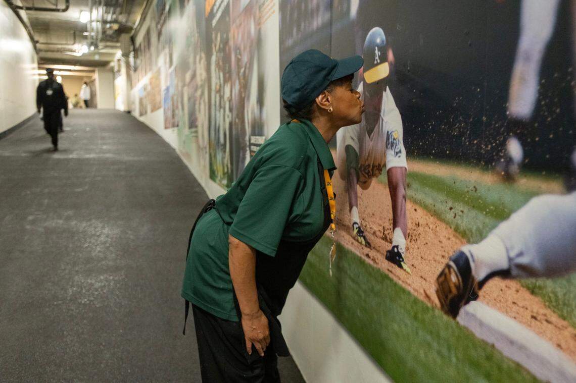 Concession worker Wendy Gaythos kisses a photo of Ricky Henderson before the Oakland A’s play the Texas Rangers in the team’s final game at Oakland-Alameda County Coliseum on Thursday. Gaythos has worked at the stadium since 1996 and has been coming to A’s games since 1975.