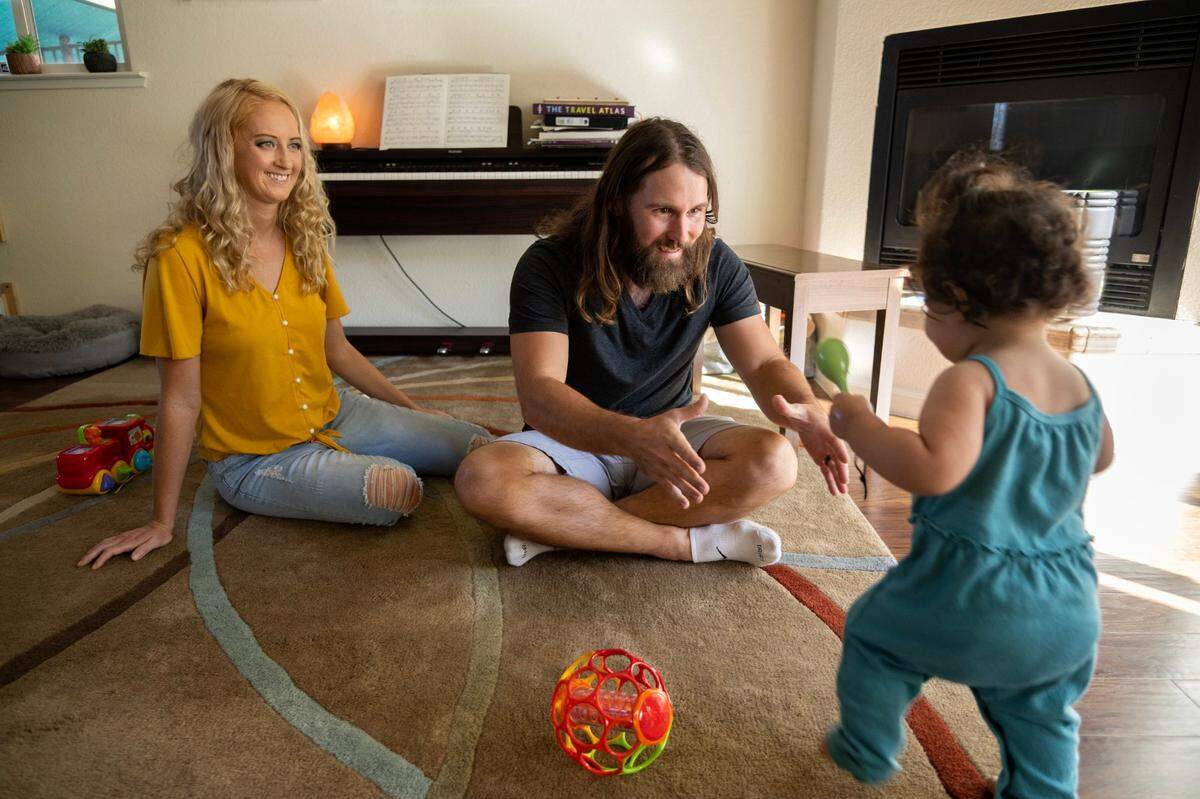 Adam and Jill Ingwell play with their adopted daughter, Sawyer, at home in Copperopolis in August.