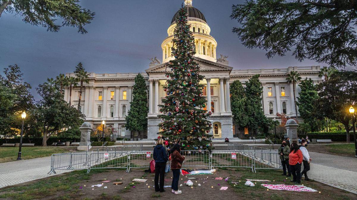 Participants in a Sacramento Regional Coalition for Palestinian Rights rally make an appearance at Capitol Christmas tree on Tuesday evening. There will be a virtual tree lighting ceremony on Wednesday.